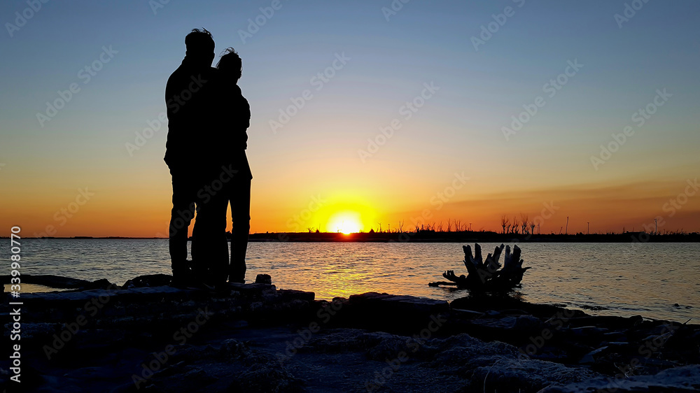 couple in love at sunset by the lake