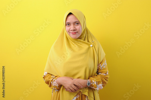 Canvas Print Portrait of a confident Asian Muslim woman standing isolated on yellow