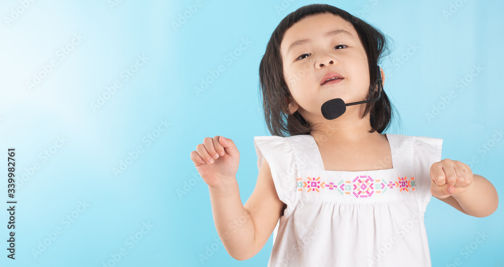 Cute Asian girl wearing voice headphones with a microphone and copy space. Cute Asian girl wearing voice headphones with a microphone and copy space.