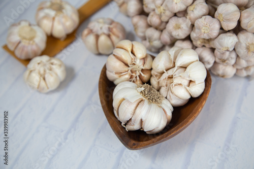 Garlic is placed on the white table in the kitchen, preparing for cooking,
Concept: The ingredients of vegetarian ingredients are very much about nature for good health, background  aromatic herbs 
