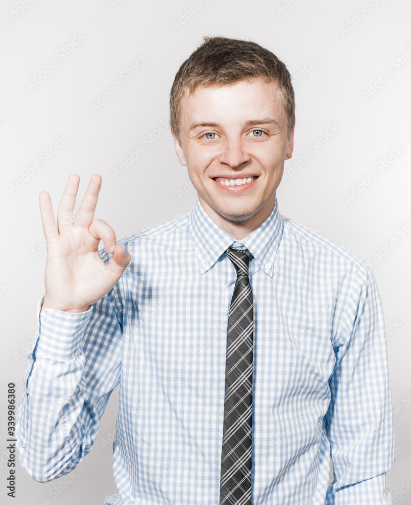 Portrait of a young successful business man shows ok Portrait of a young successful business man shows ok
