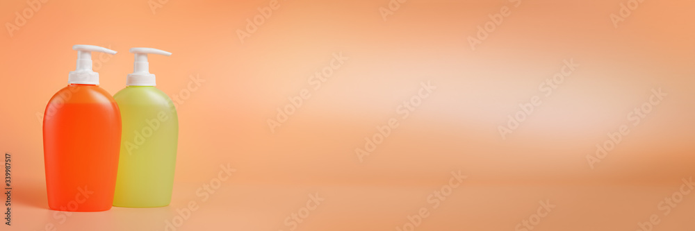 Two colored liquid soap dispensers on long peach colored background with copy space Two colored liquid soap dispensers on long peach colored background with copy space