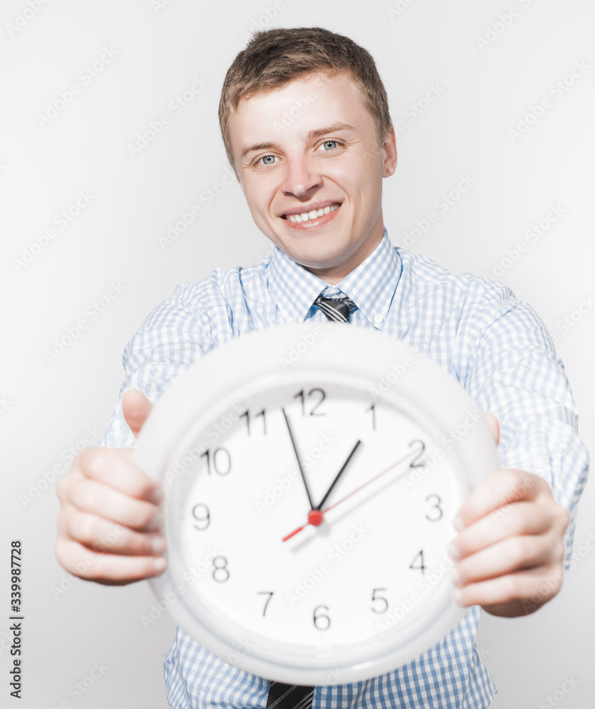 Discontented businessman holding wall clock. Discontented businessman holding wall clock.