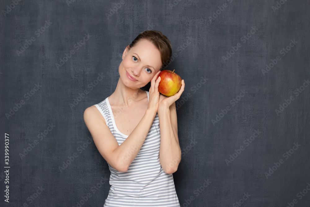 Portrait of happy girl holding ripe apple in hands and smiling Portrait of happy girl holding ripe apple in hands and smiling