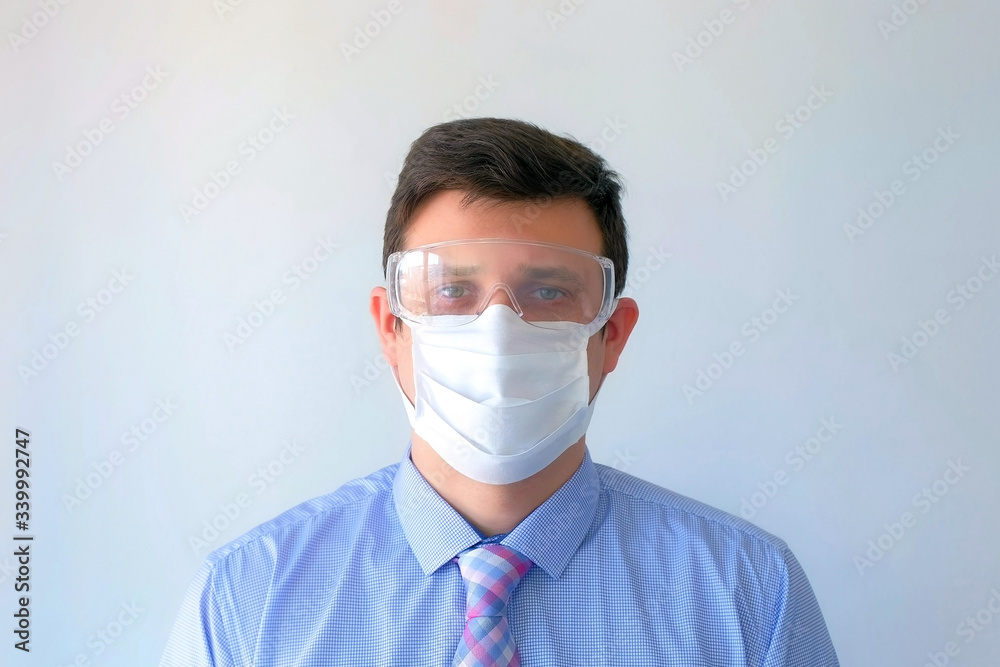 Portrait of man breathing deep in protective mask and glasses on face, coronavirus pandemic. Man office worker on white background. Worldwide global COVID-19 epidemic. Fighting 2019-ncov infection. Portrait of man breathing deep in protective mask and glasses on face, coronavirus pandemic. Man office worker on white background. Worldwide global COVID-19 epidemic. Fighting 2019-ncov infection.