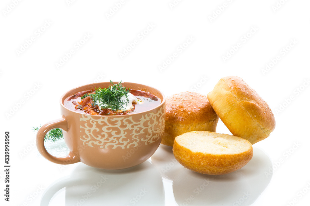 hot beetroot soup with sour cream, herbs and rolls in a ceramic bowl hot beetroot soup with sour cream, herbs and rolls in a ceramic bowl