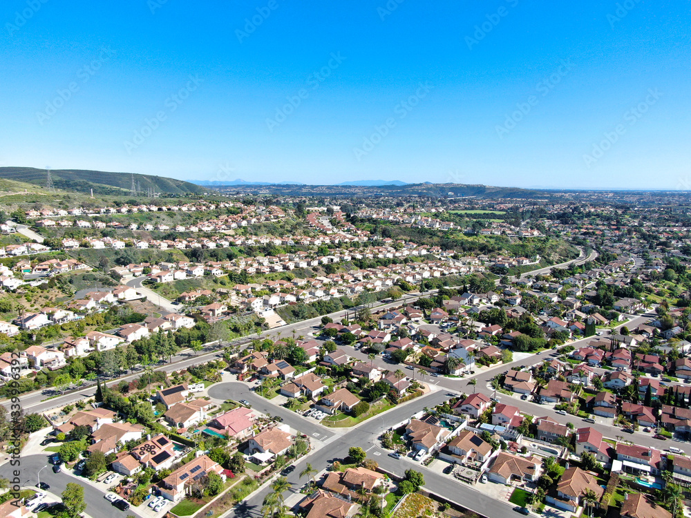 Aerial view of upper middle class neighborhood with residential subdivision mansion and swimming pool during with blue sky in San Diego, California, USA.