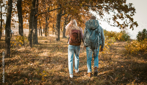 Hiking of Young Couple With Backpacks Holding Hands
