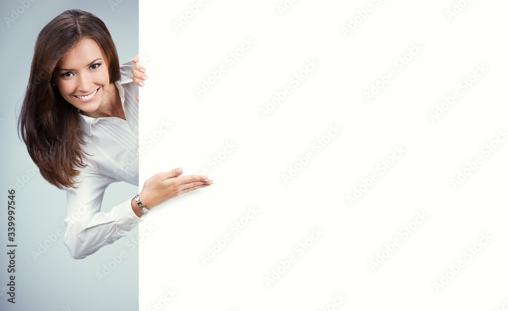 Happy young woman showing blank sign board with copy space for some slogan, text or imaginary. Business ad concept. Multiracial Asian Chinese / Caucasian model over grey background. Happy young woman showing blank sign board with copy space for some slogan, text or imaginary. Business ad concept. Multiracial Asian Chinese / Caucasian model over grey background.
