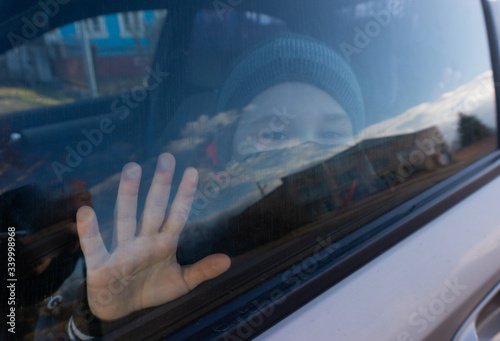 a boy in a black mask behind a car window