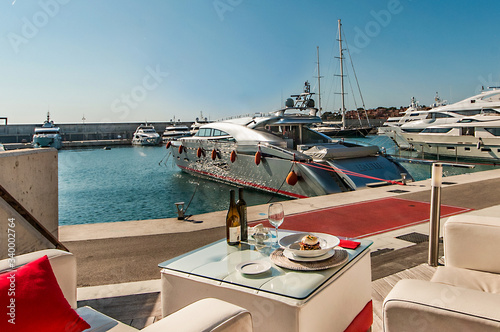 Mediterranean food on the terrace of a restaurant in a marina.
