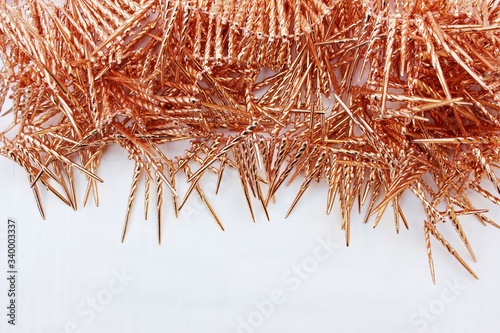 Shiny golden tinsel for Christmas tree decoration isolated on white. Christmas background for textan white background. Multi-colored rain.