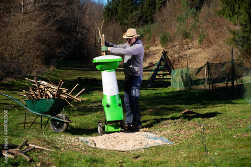 Garden shredder or wood chipper for shredding tree or shrub cuttings. photo