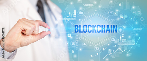 Doctor giving a pill with BLOCKCHAIN inscription, new technology solution concept