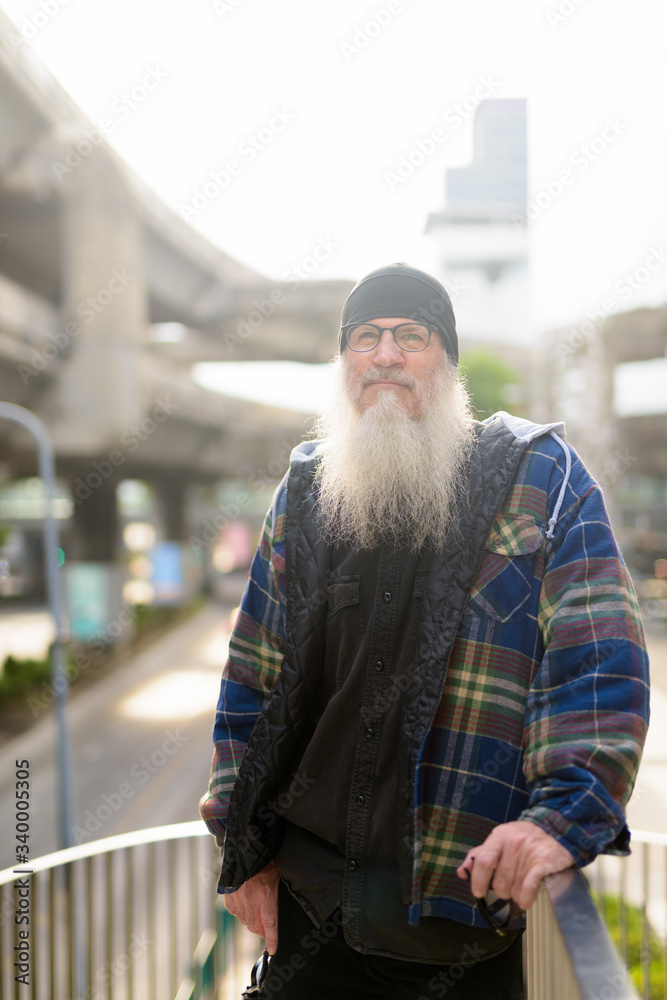 Mature bearded hipster man thinking at footbridge in the city Mature bearded hipster man thinking at footbridge in the city