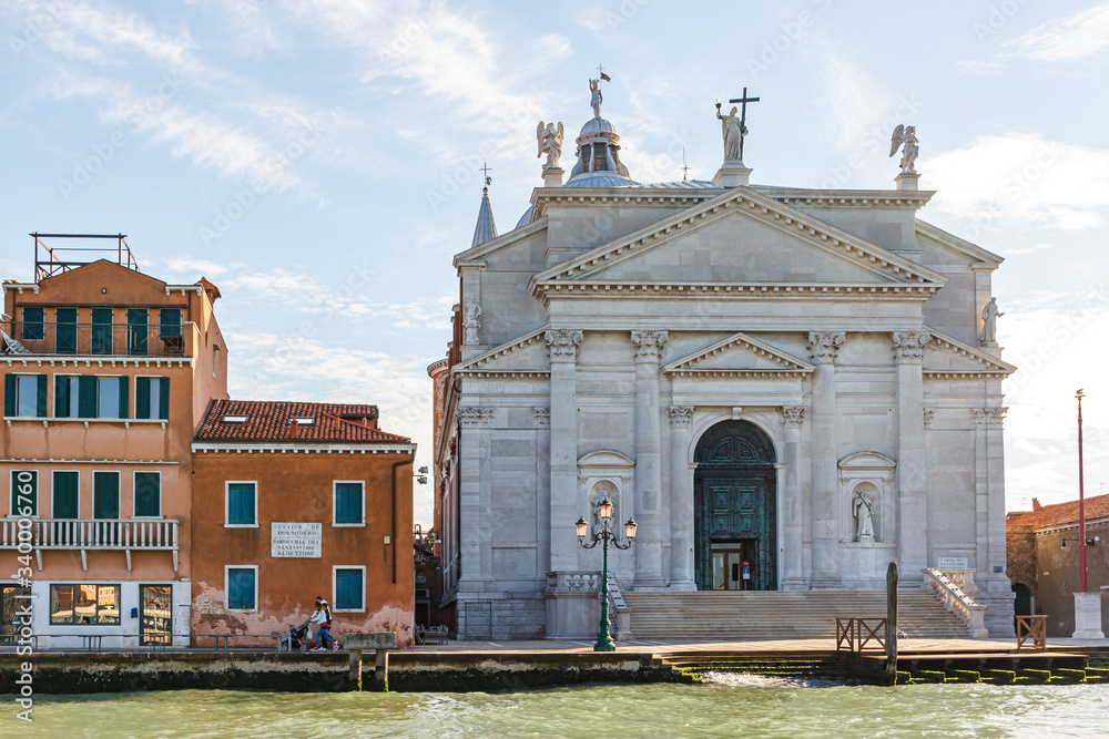 Fototapeta premium Water channels of Venice city. Church of the Santissimo Redentore and Galleria Il Redentore buildings are on Grand Canal in Venice, Italy.