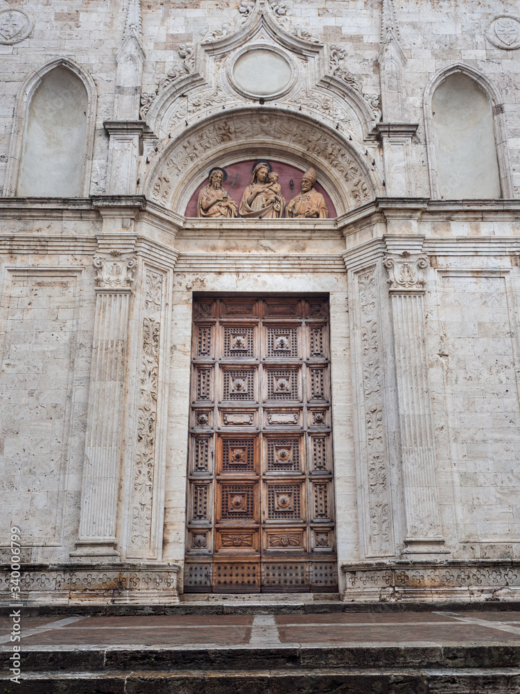 The wooden carved portal of an ancient cathedral in Italy.