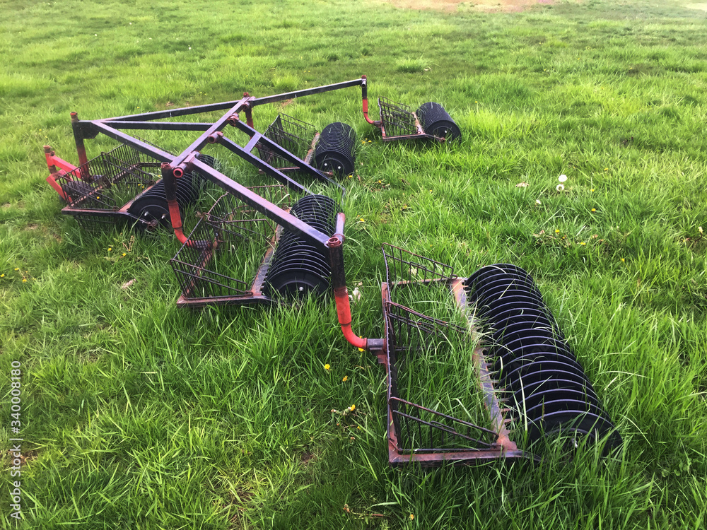 Grass and weeds overrun equipment that is used to collect balls on a golf driving range. 