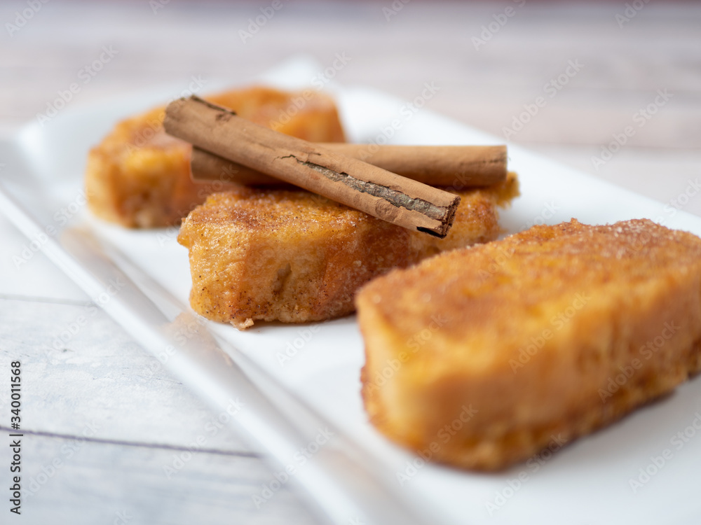three french toast with cinnamon on white plate and light background three french toast with cinnamon on white plate and light background