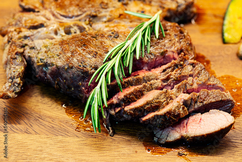 Beef steak grilled with spice peper origano Himalayan pink salt olive oil decorated with rosemarry on top and vegetable grilled on the wooden plate photo