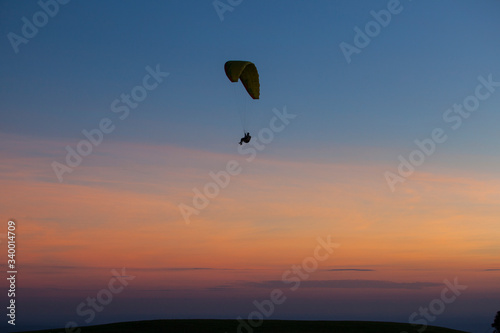 Paragliding silhouette flying at sunset, Brazil
