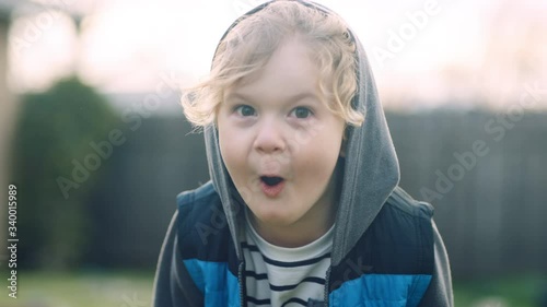 4 year old does dinosaur roar impression to camera with smile in slow motion