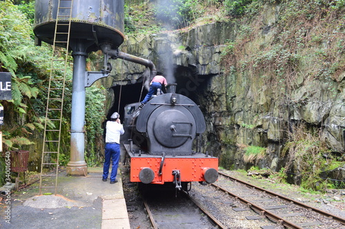 Photo Rear View Of Men Filling Water In Steam Train