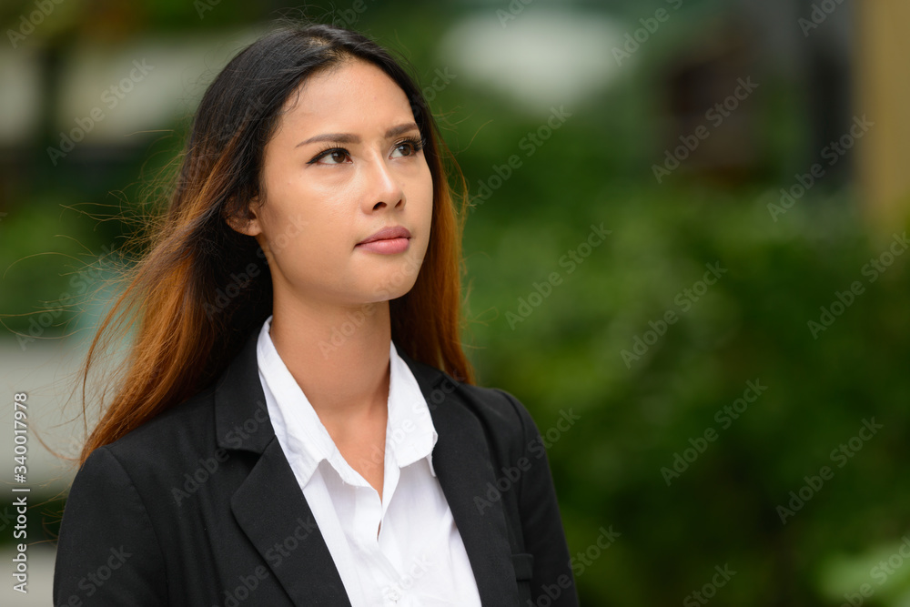 Young beautiful Asian businesswoman thinking in the park Young beautiful Asian businesswoman thinking in the park