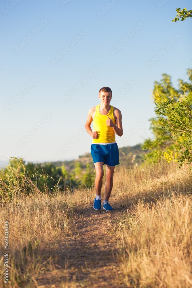 Young man running on a rural road during sunset Young man running on a rural road during sunset