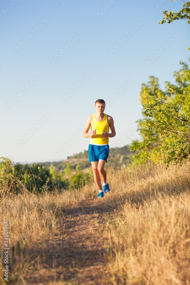 Young man running on a rural road during sunset Young man running on a rural road during sunset