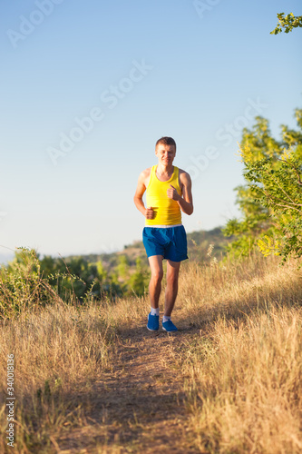Young man running on a rural road during sunset © aeroking