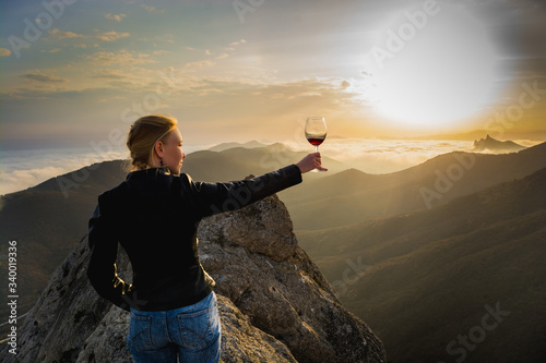 Girl with a glass in the mountains