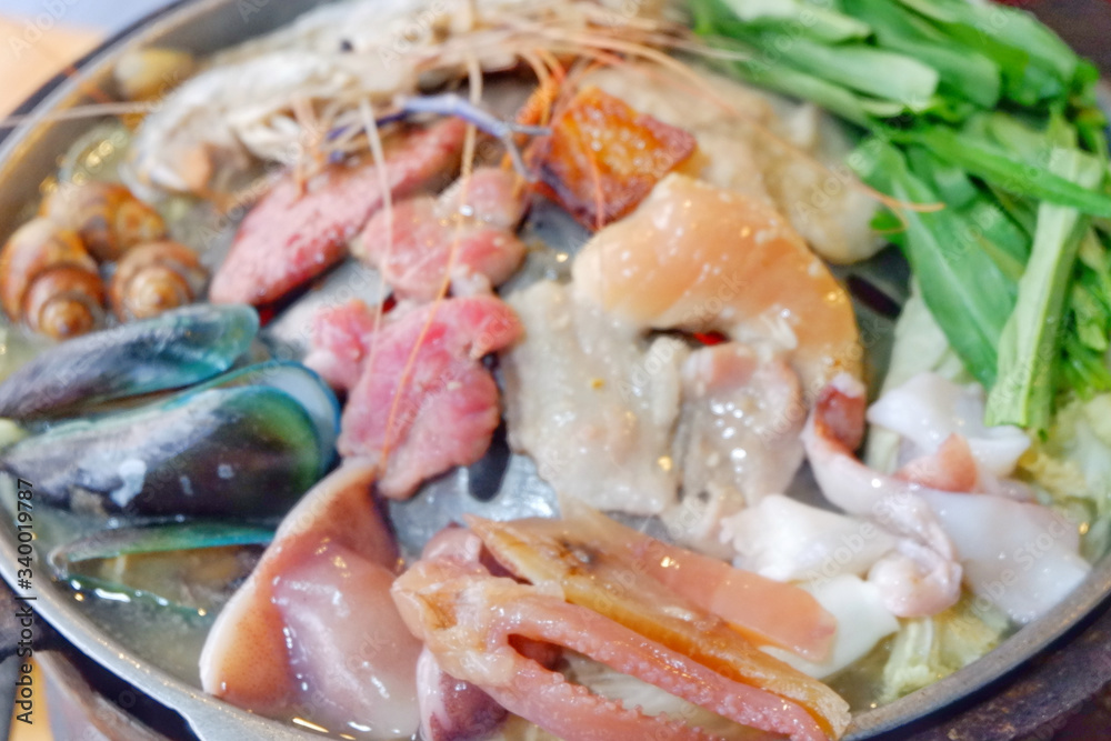 Sliced Pork and seafood on Thai Styled Coal Grill and Shabu Pan.Shrimp Clams in a Hot Pan.Close up.
Sliced Pork and seafood on Thai Styled Coal Grill and Shabu Pan.Shrimp Clams in a Hot Pan.Close up.