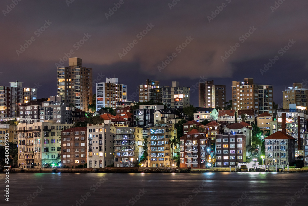 Residential and commercial buildings at Sydney Harbor at night, Australia.