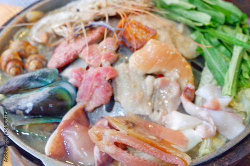 Sliced Pork and seafood on Thai Styled Coal Grill and Shabu Pan.Shrimp Clams in a Hot Pan.Close up. 
