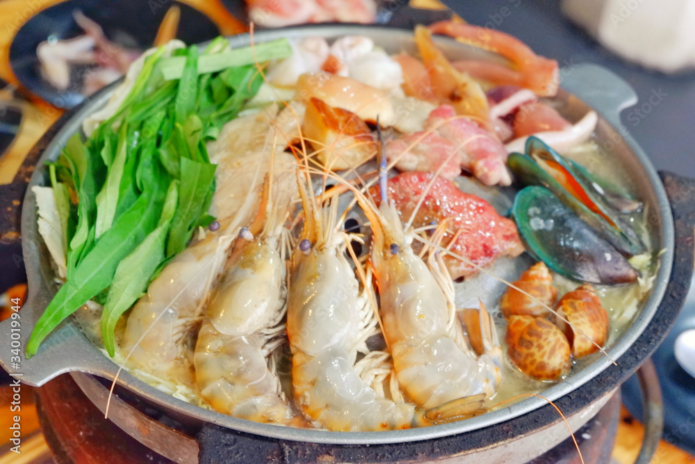 Sliced Pork and seafood on Thai Styled Coal Grill and Shabu Pan.Shrimp Clams in a Hot Pan.Close up.
Sliced Pork and seafood on Thai Styled Coal Grill and Shabu Pan.Shrimp Clams in a Hot Pan.Close up.
