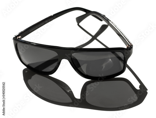 black sunglasses on a white background with a shadow from the sun