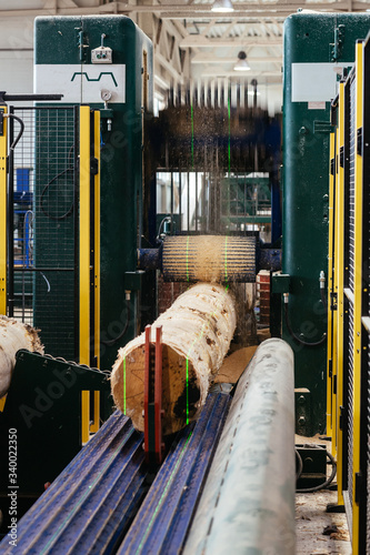 sawing a log at a sawmill using a machine, automatic production at a woodworking plant, factory