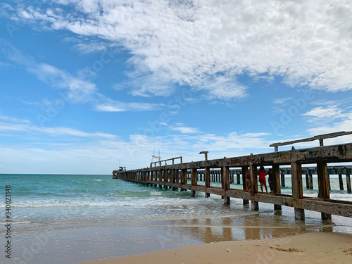 Nature landscape. Amazing sandy tropical beach with bridge and tree in crystal clear sea and scenery wooden bridge out of the horizon / Palm and tropical beach.Close up.