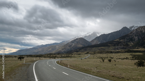 Road leading towards mountains, with cloudy sky. High perspective shot made in Aoraki / Mt Cook National Park in New Zealand.