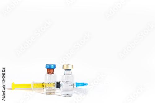 Syringe and vaccine bottles isolated on white
