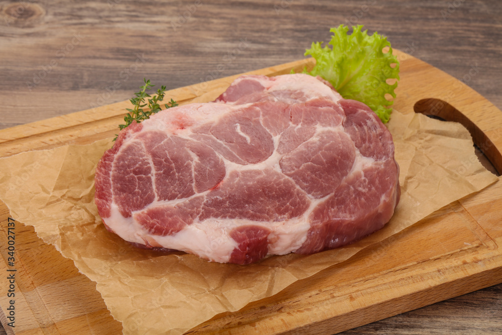 Raw pork steak over wooden board Raw pork steak over wooden board