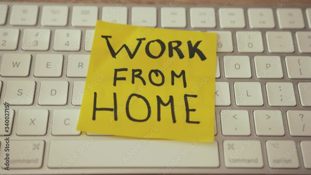 Work from home yellow sticker on white computer keyboard. Handwritten note inscription. Reminder. Home workplace, freelance. Work from home yellow sticker on white computer keyboard. Handwritten note inscription. Reminder. Home workplace, freelance.