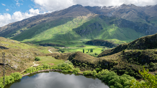 Small lake with lush green hills, landscape shot made in New Zealand © Peter Kolejak