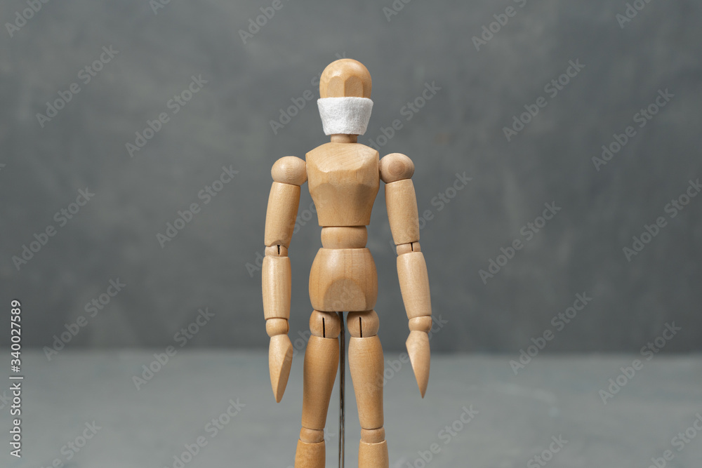 Wooden mannequin in a medical mask of personal protection. Wooden mannequin in a medical mask of personal protection.