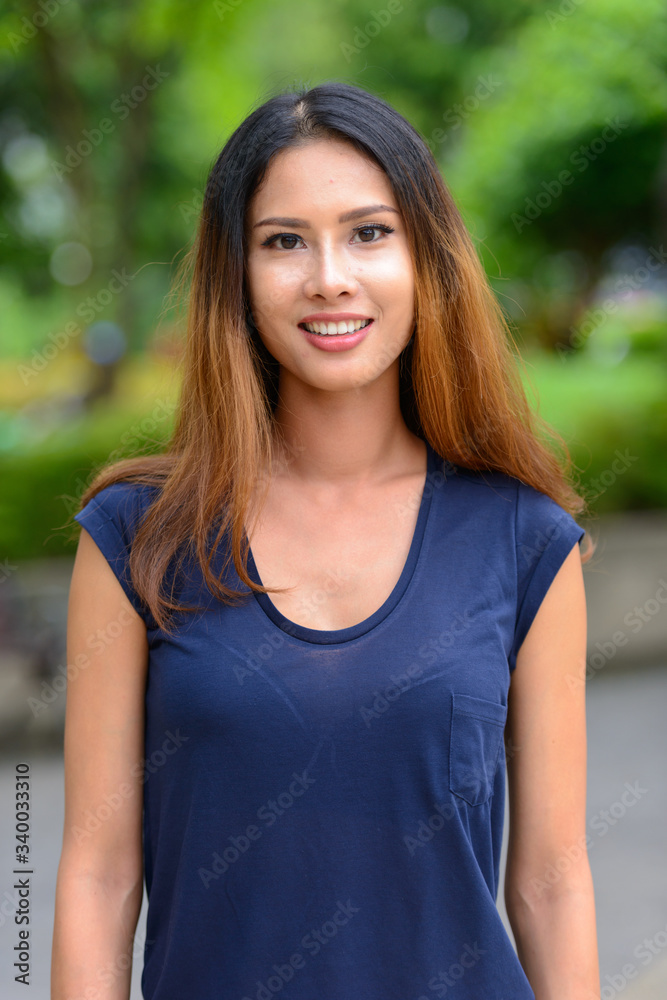 Happy young beautiful Asian businesswoman in the park Happy young beautiful Asian businesswoman in the park