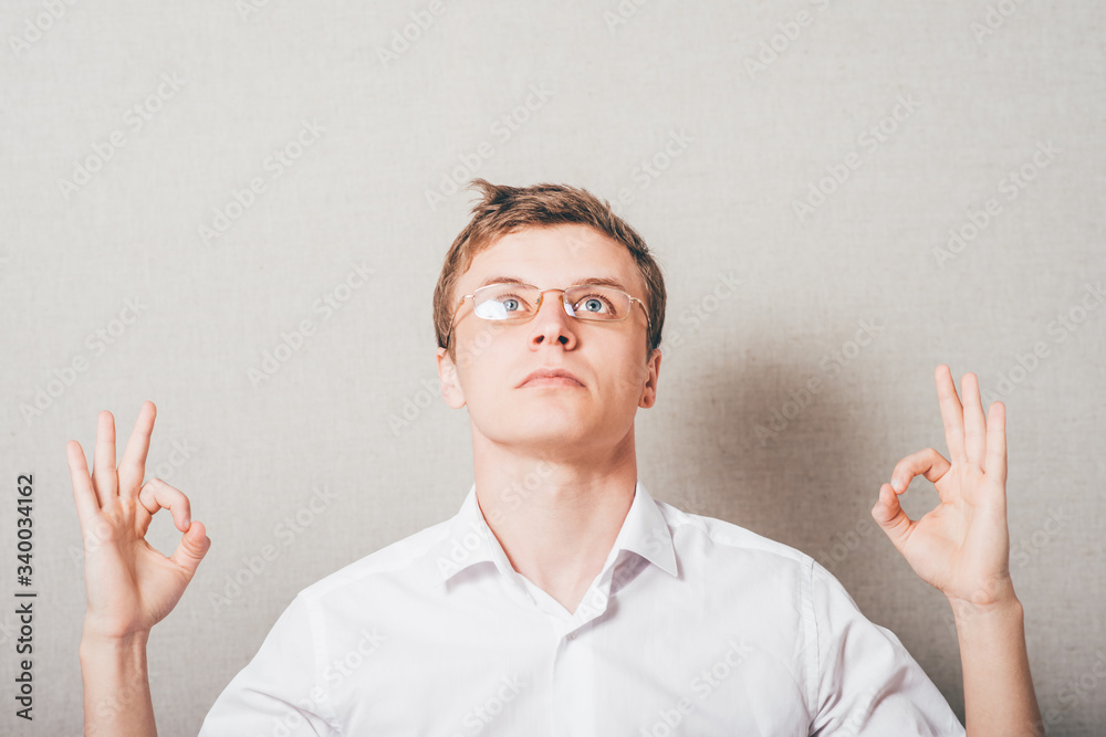 The man with glasses meditating. On a gray background. The man with glasses meditating. On a gray background.