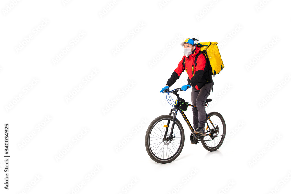 Too much orders. Contacless delivery service during quarantine. Man delivers food during isolation, wearing gloves and face mask. Taking pizza on bike isolated on white background. Safety. Hurrying up Too much orders. Contacless delivery service during quarantine. Man delivers food during isolation, wearing gloves and face mask. Taking pizza on bike isolated on white background. Safety. Hurrying up