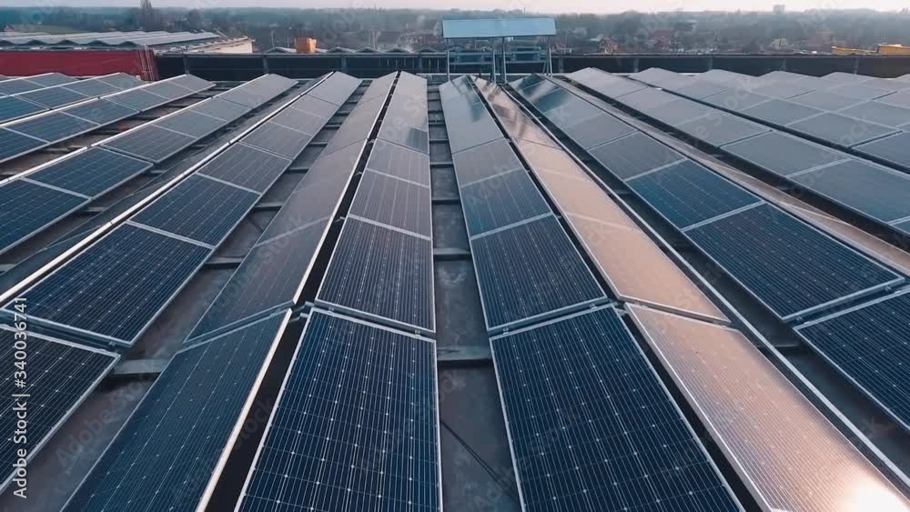 Rows of solar panels on roof at sunset. Photovoltaic green energy generator. Sunny batteries on the top of the building getting ecological energy from the sun.