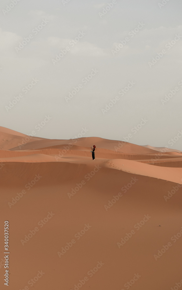 Una mujer mira el horizonte en el desierto del sahara